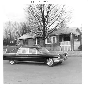Black and white photo of hearse in front of Mynatt Funeral Home