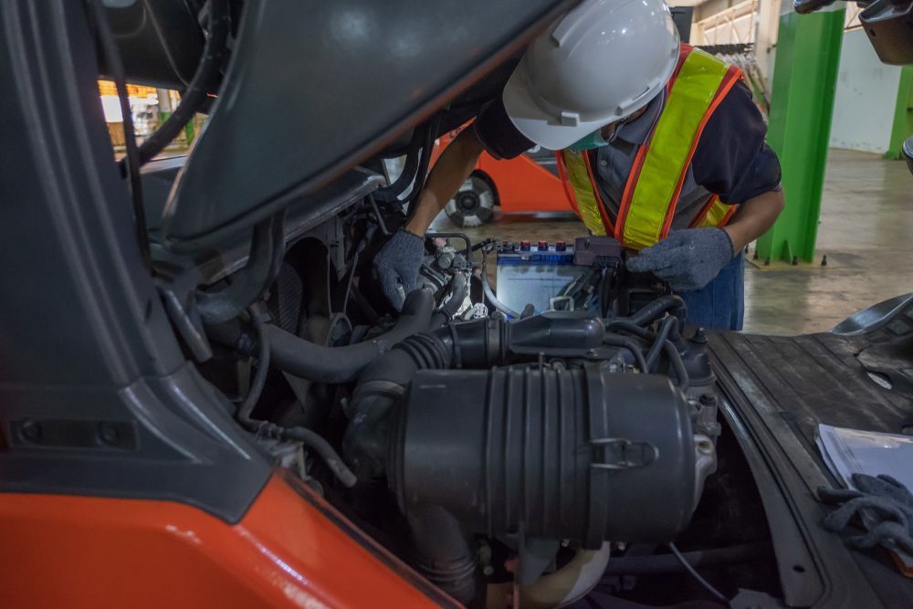 Mechanic in Hard Hat and Safety Vest Inspecting an Engine — Forklift Repairs & Spares In Maryborough, QLD