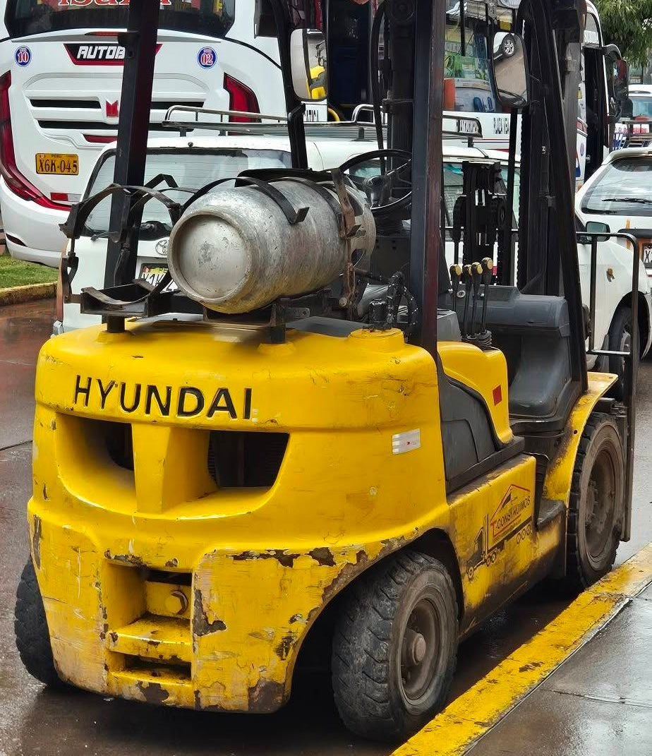 Yellow Hyundai Forklift Parked Outdoors On A Wet Street, With A Silver Tank On The Back — Forklift Repairs & Spares In Svensson Heights, QLD