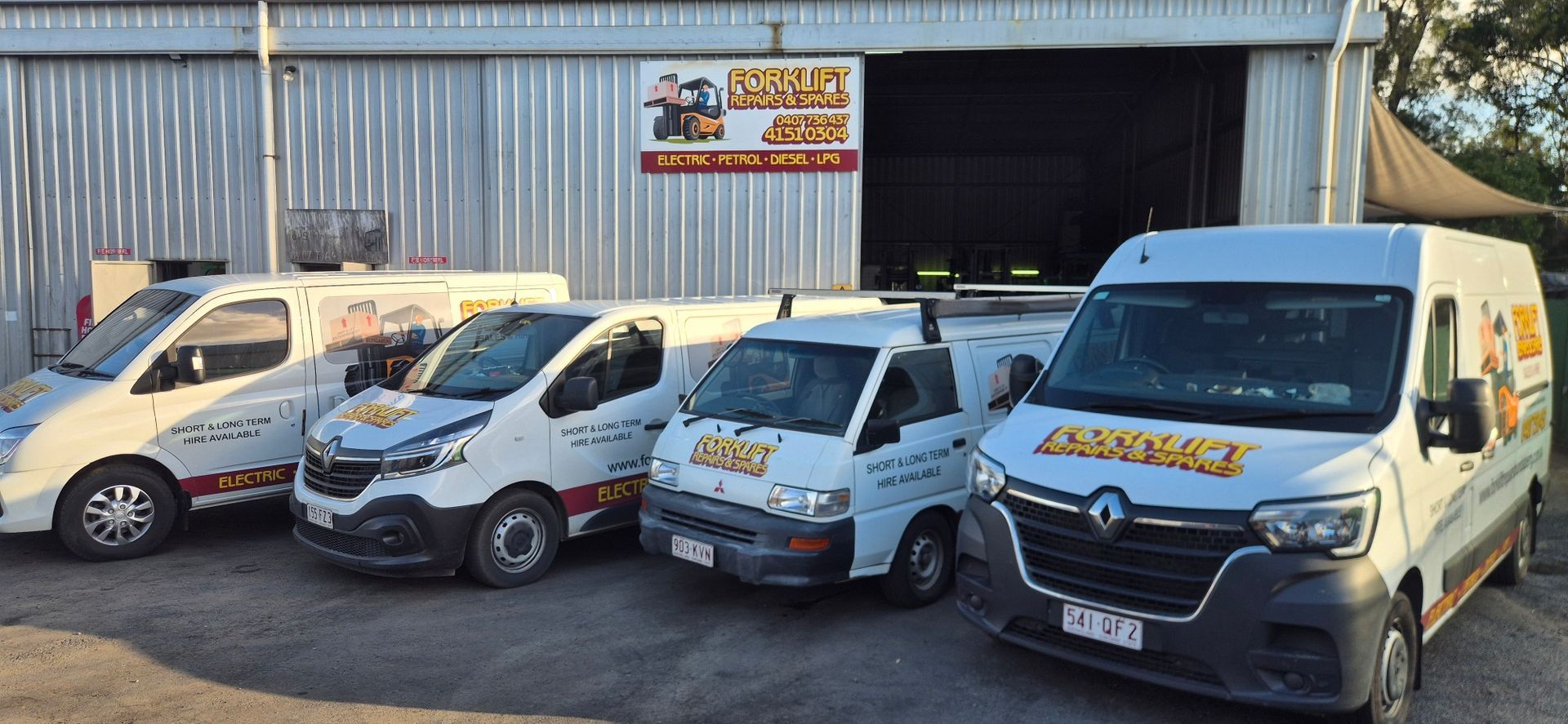 Four White Delivery Vans Parked Outside A Warehouse With An Open Garage Door — Forklift Repairs & Spares In Svensson Heights, QLD