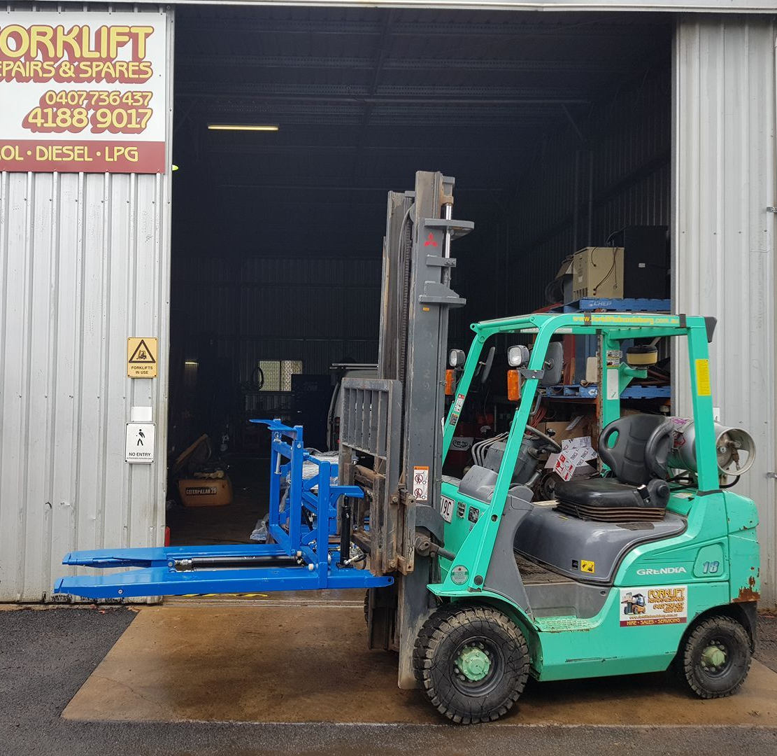 Green Forklift Moving A Blue Pallet Rack In A Warehouse Doorway — Forklift Repairs & Spares In Svensson Heights, QLD