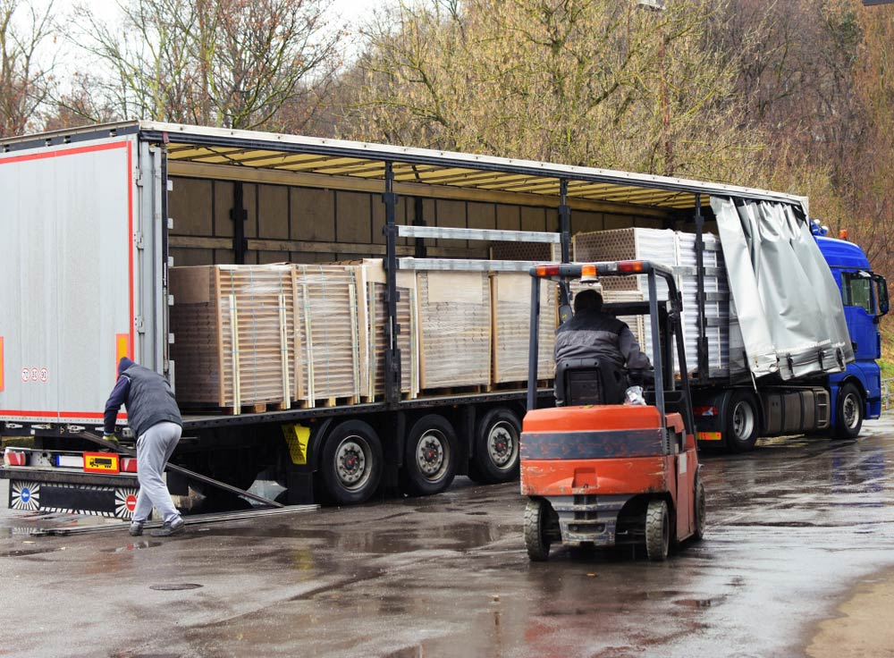 Forklift Unloading Palletised Boxes From a Covered Truck — Forklift Repairs & Spares In Svensson Heights, QLD