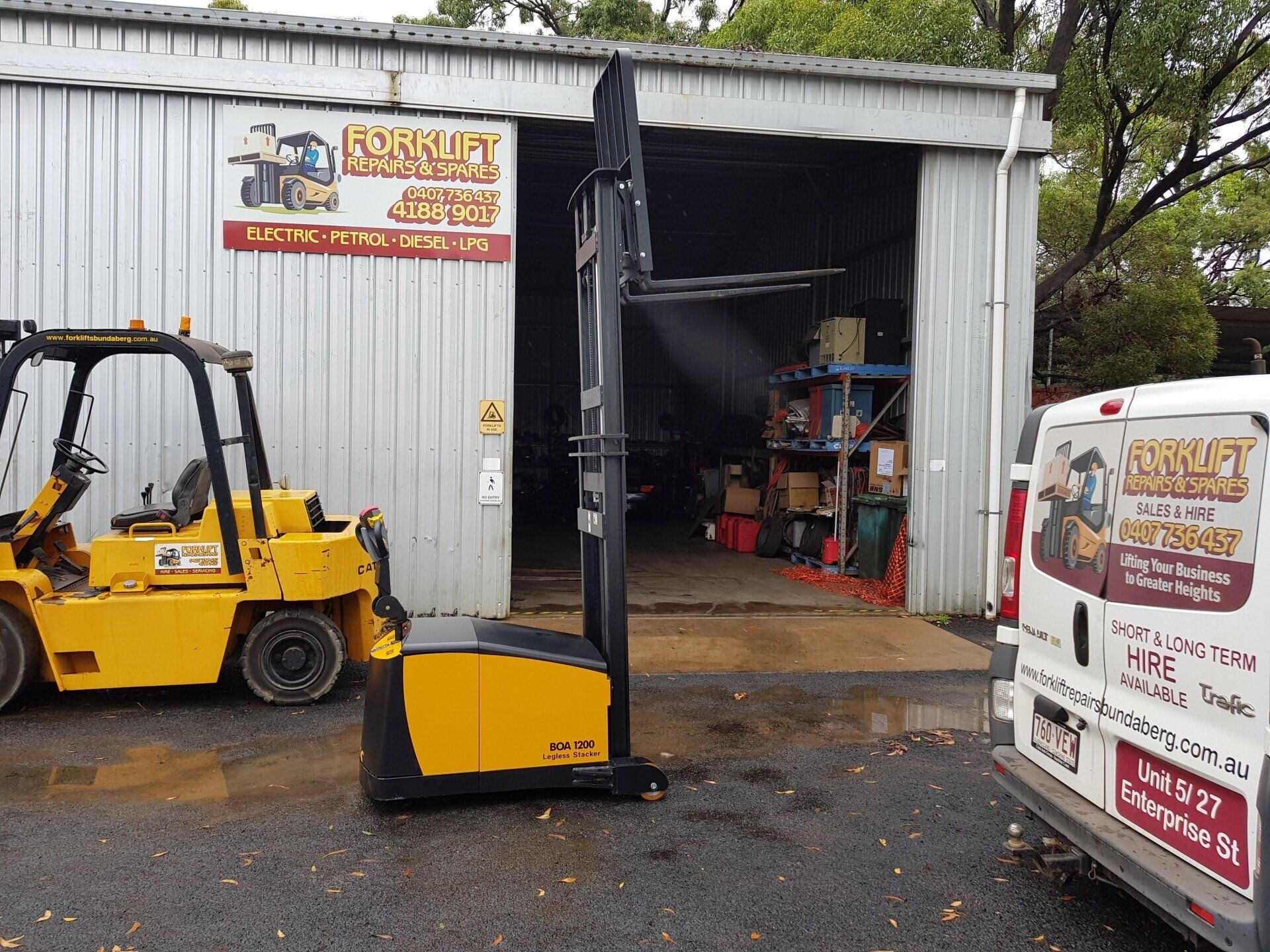 Yellow Forklift Outside a Metal Workshop With an Open Garage — Forklift Repairs & Spares In Svensson Heights, QLD