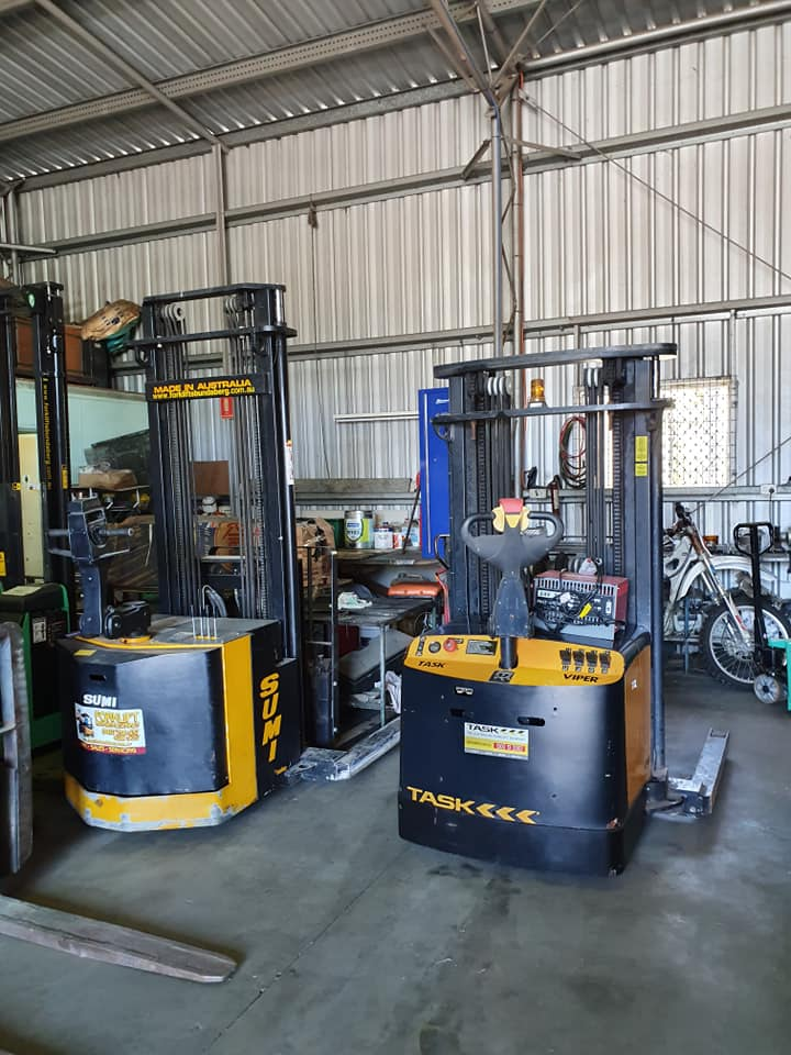 Forklifts Parked Inside a Warehouse With Metal Walls and Concrete Floor — Forklift Repairs & Spares In Svensson Heights, QLD