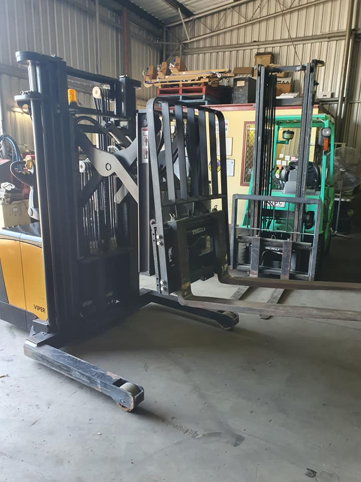 Forklift in a Warehouse Lifting a Green Machine — Forklift Repairs & Spares In Svensson Heights, QLD