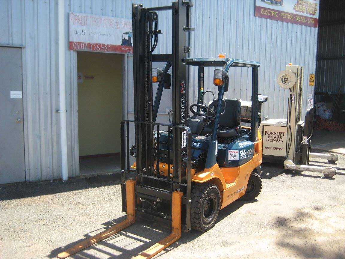 Orange Forklift Parked Outside a Warehouse — Forklift Repairs & Spares In Maryborough, QLD