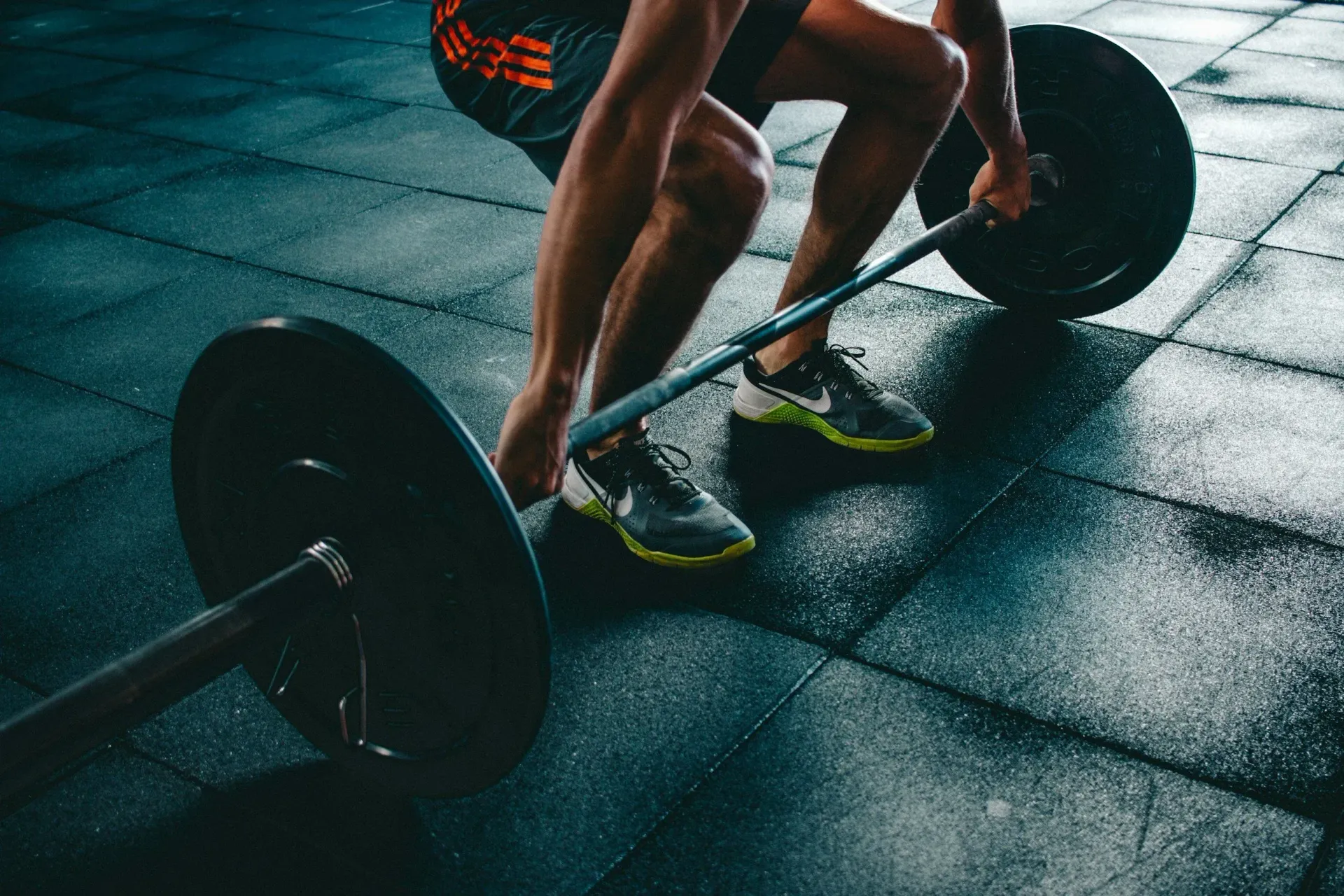 Man lifting barbell in gym.