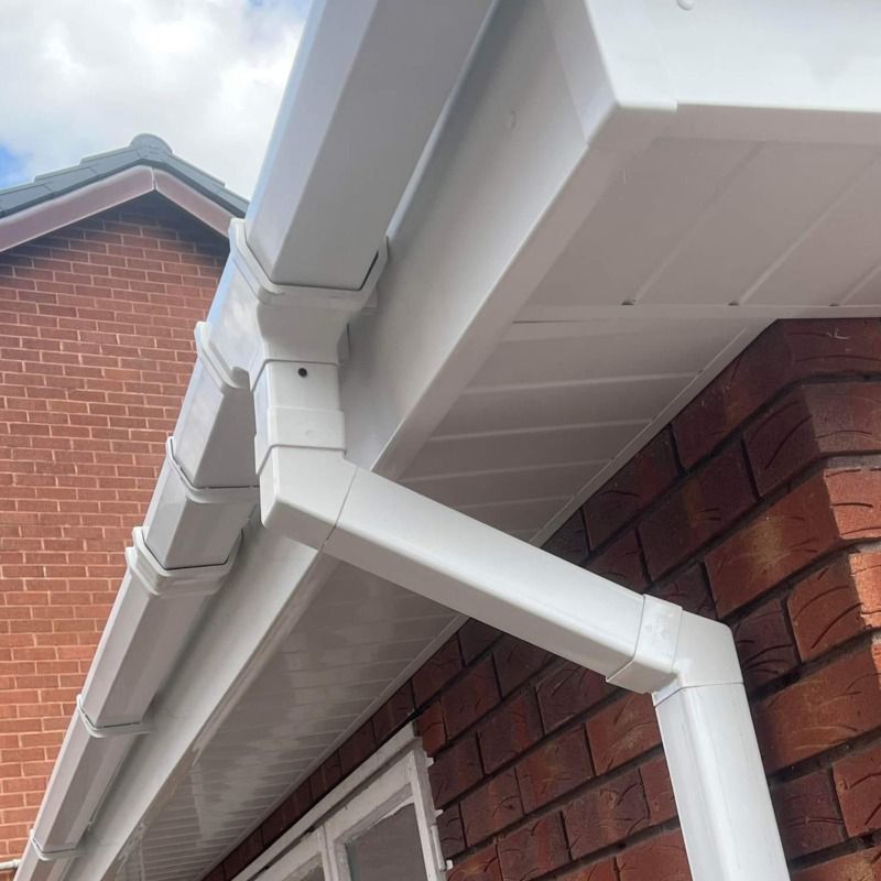 White gutter system on a brick house, angled view.
