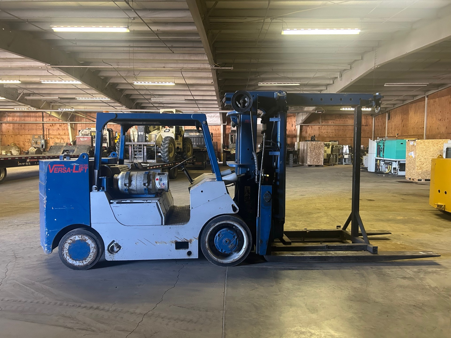 Yellow forklift lifting multiple sacks of goods inside a warehouse.