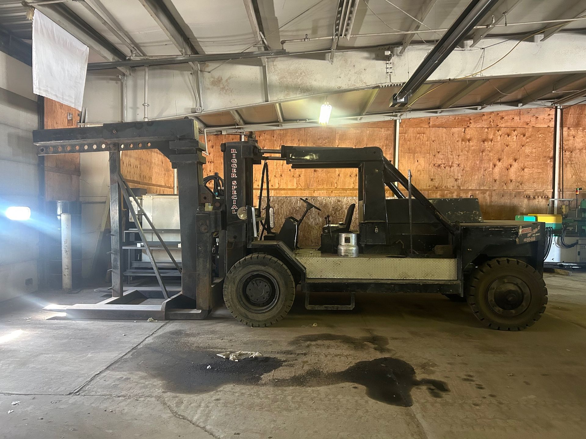 Yellow forklift loading pallets of goods at a warehouse loading dock.