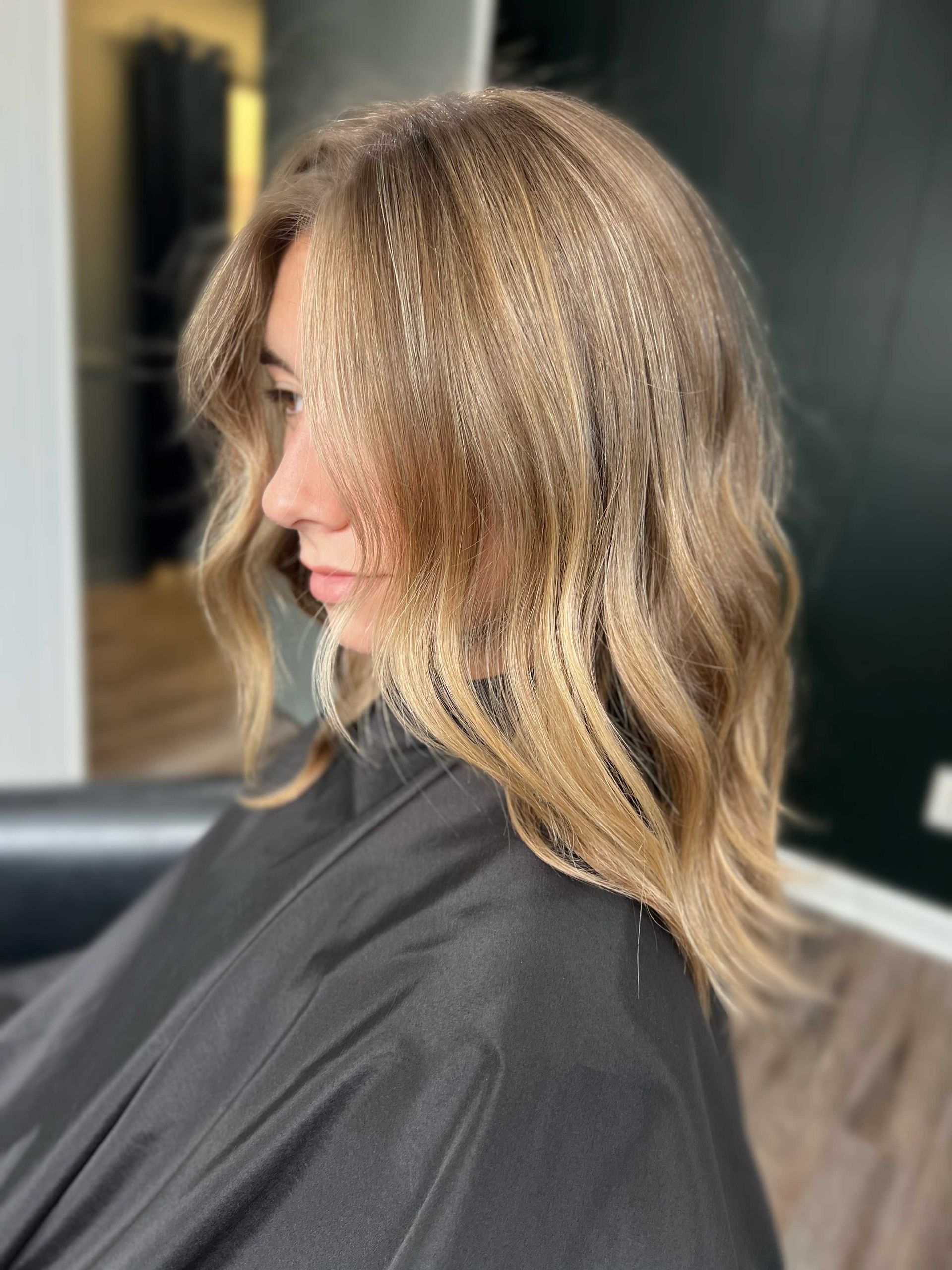 woman in salon chair with blonding specialitist haircut Boone NC