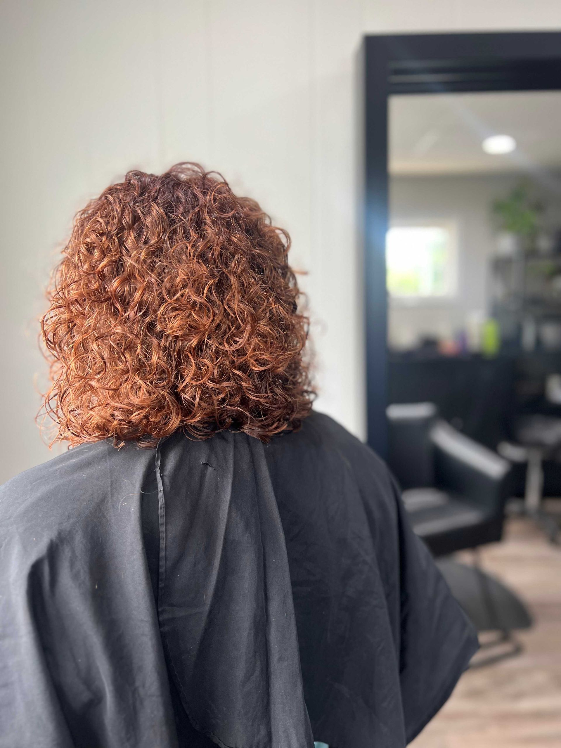 curly red hair cut in hair salon chair NC