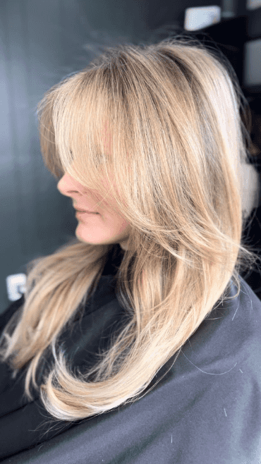 Blonde hair stylist gives new look to woman in salon chair Boone NC