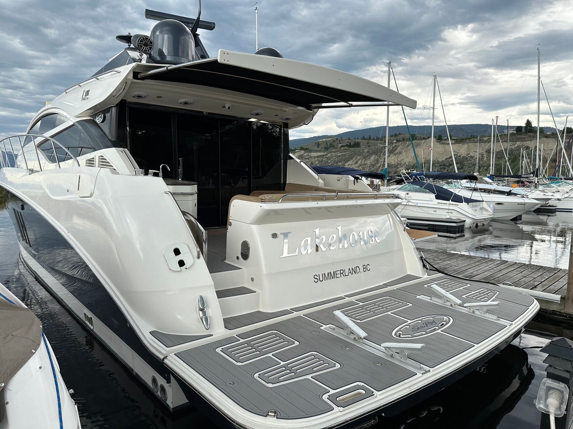 A large white yacht is docked at a marina.