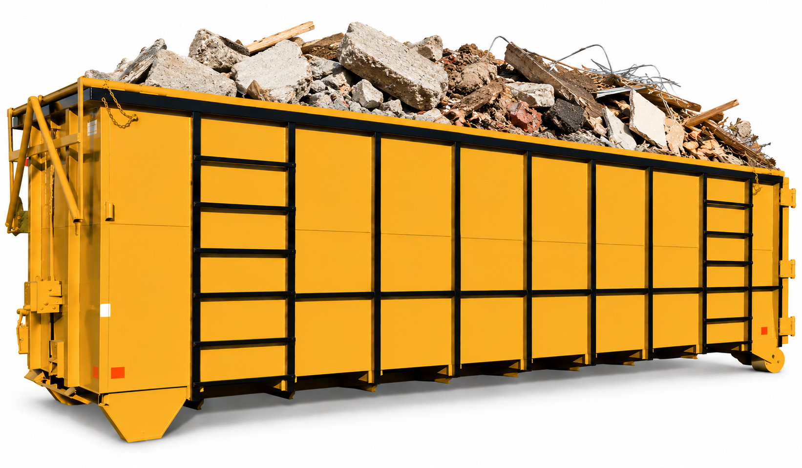 Green metal dumpster filled with trash in a paved outdoor area beside a fence