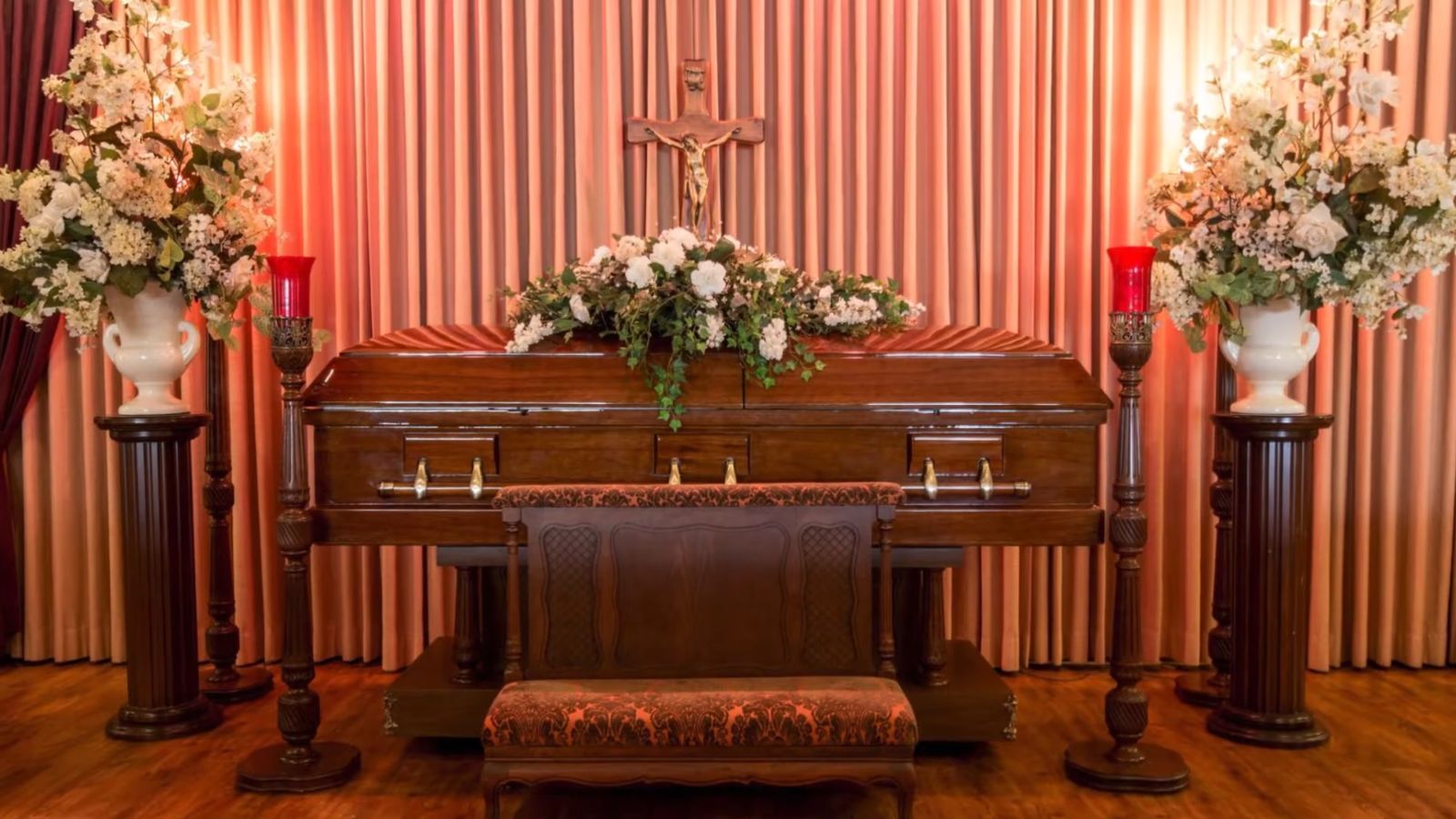 Chapel at the Caring Cremations funeral home with a wooden casket, a crucifix and flower arrangements
