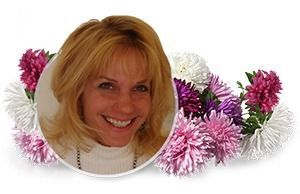 Smiling blonde woman framed by pink and white flowers on a white background