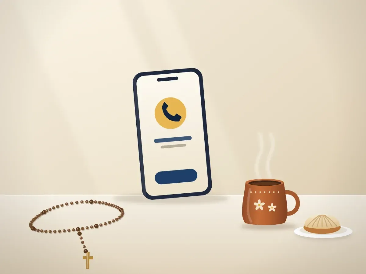 Un teléfono con una llamada en pantalla junto a un jarro de café de olla, una concha y un rosario sobre la mesa