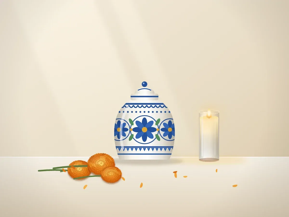 Una urna de estilo talavera junto a una veladora y flores de cempasúchil sobre una mesa con mantel de lino