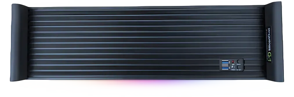 A black device with a remote control on it is sitting on a white surface.