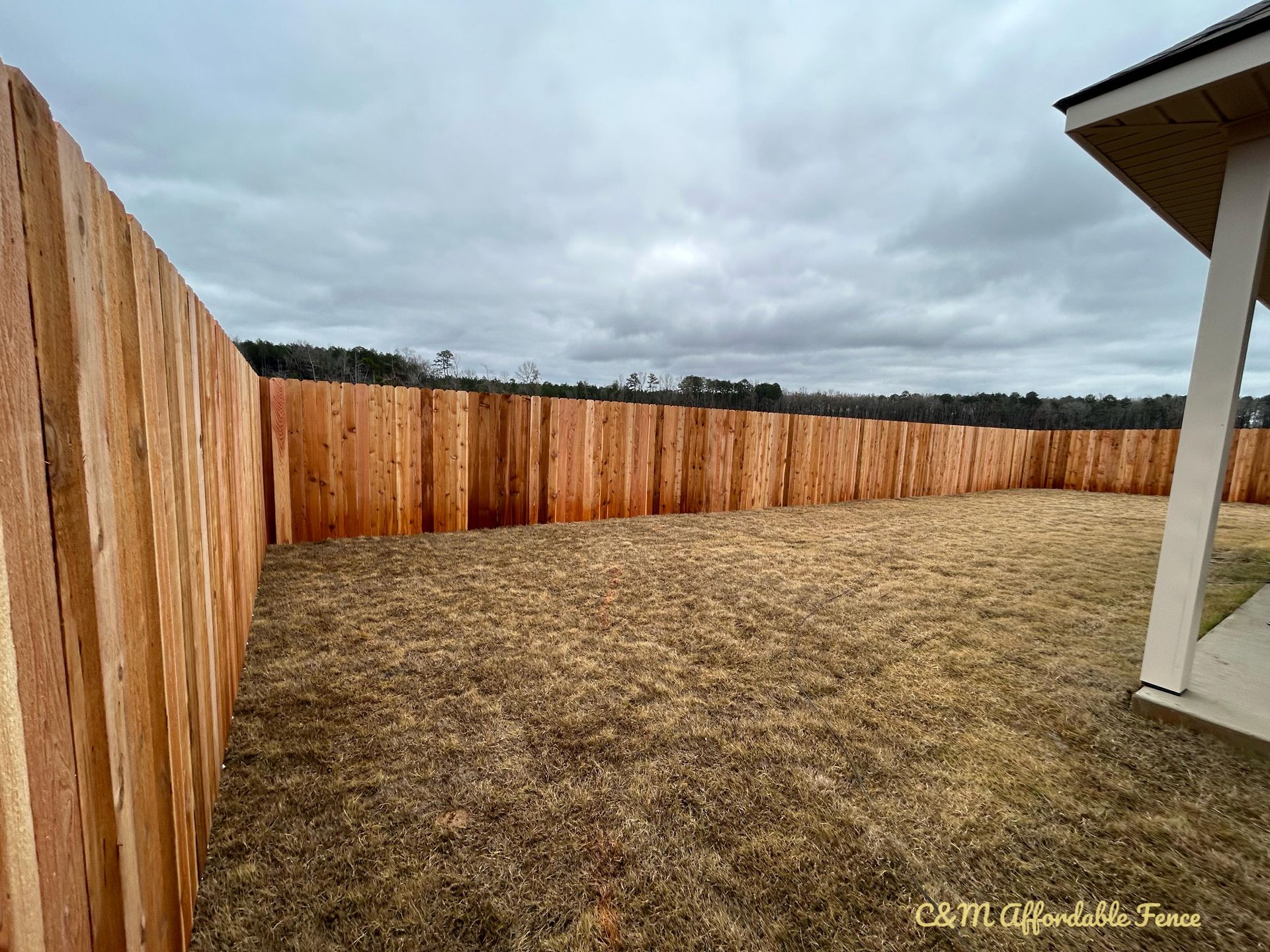There is a wooden fence in the backyard of a house.