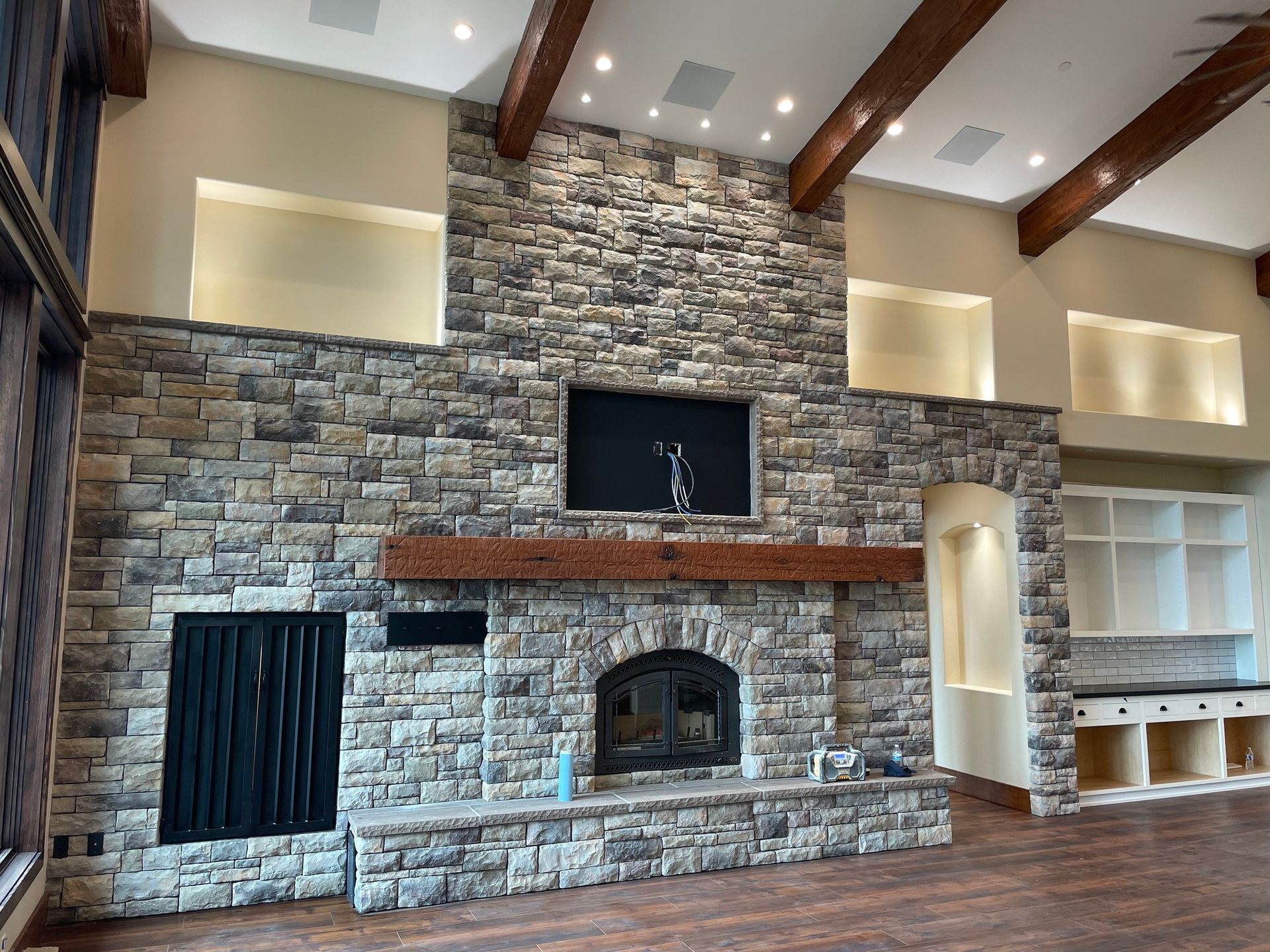 A living room with a stone fireplace and a flat screen tv