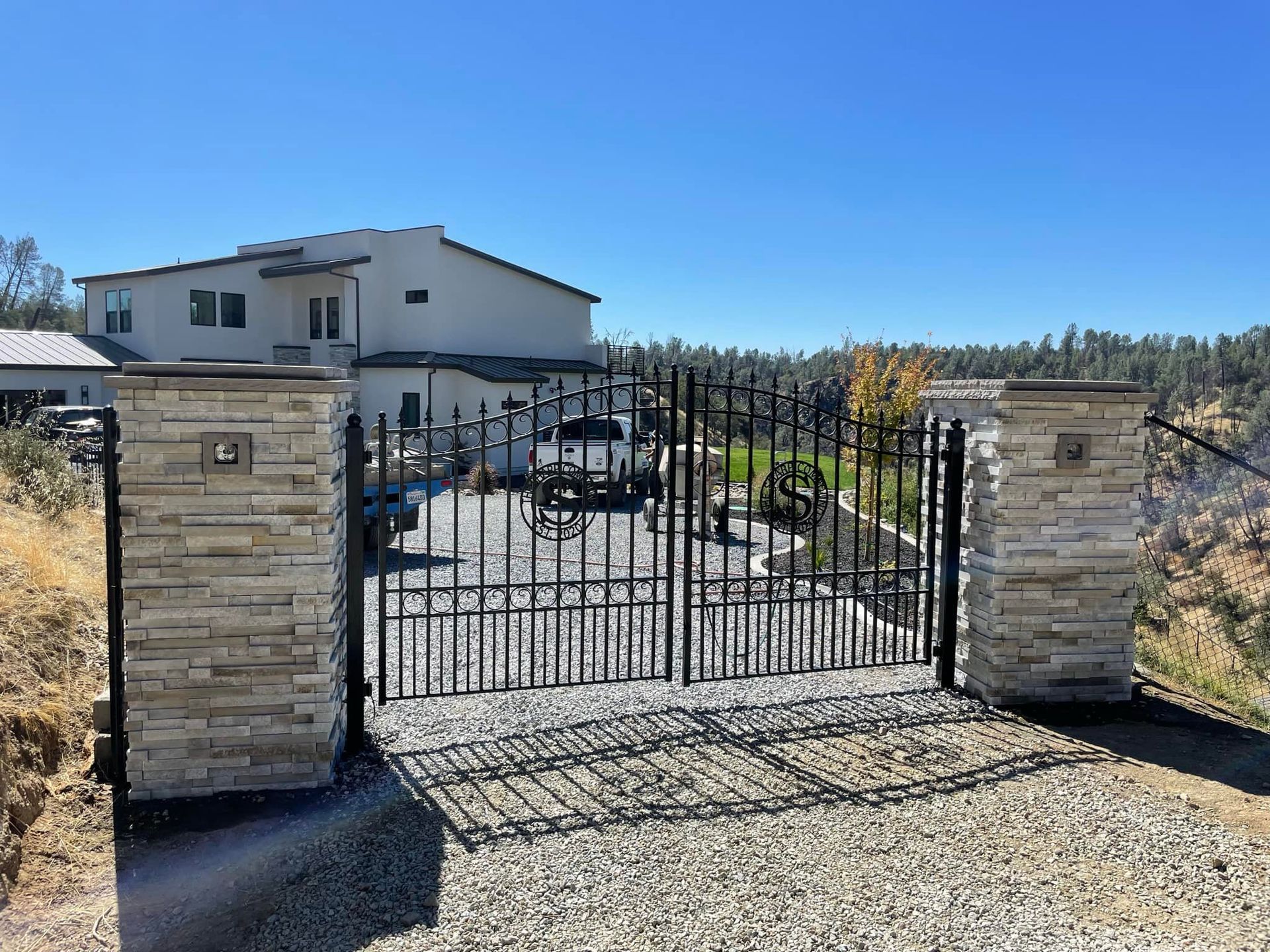 A large white house is behind a metal gate.