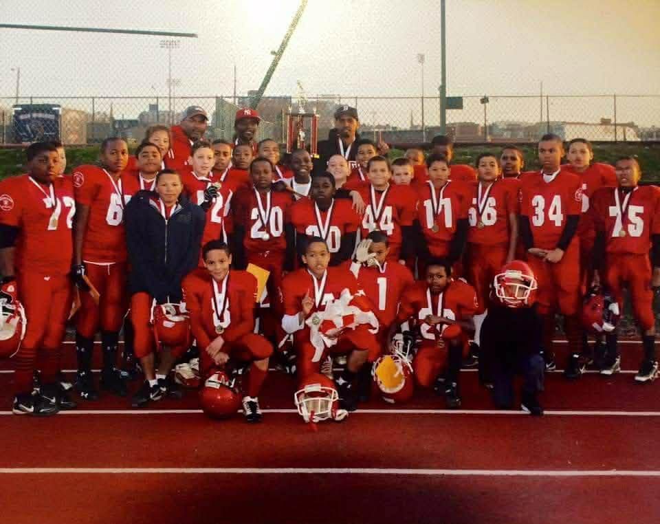 Football team in red uniforms posing for a group photo on a field
