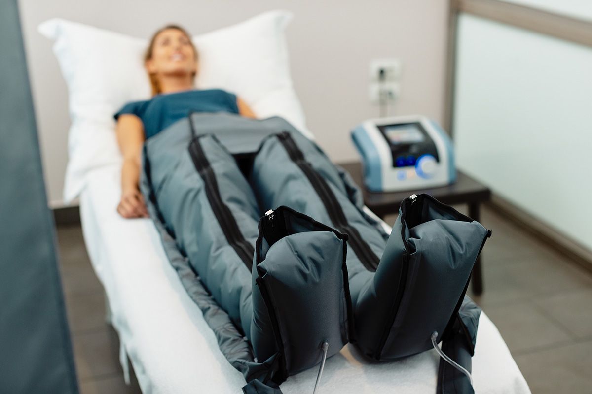 a woman is laying on a bed getting treatment on her legs
