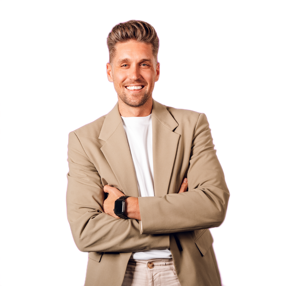 Smiling man in beige blazer and white shirt, standing with arms crossed on a white background