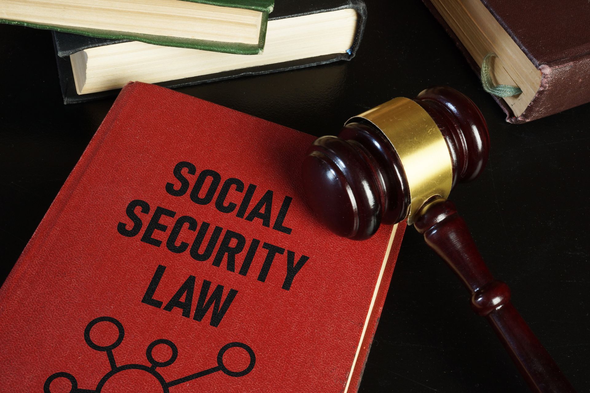 A Social Security law book lies on a desk with a judge’s gavel placed next to it. A Social Security law book lies on a desk with a judge’s gavel placed next to it.