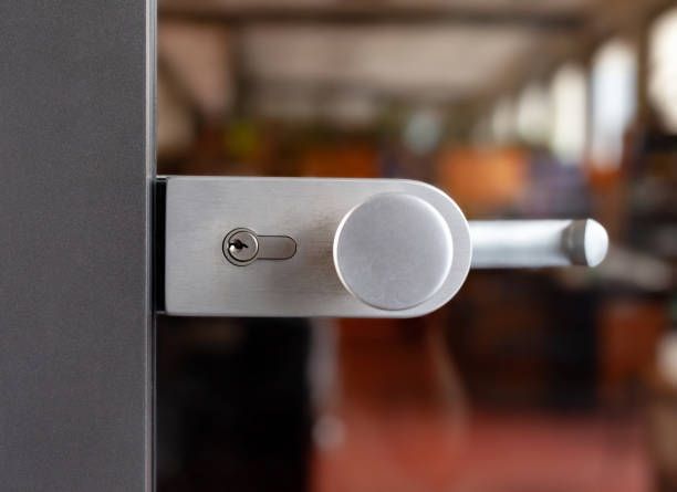 Silver door handle and lock on a glass door.