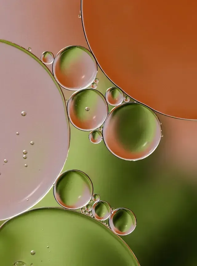 Colorful oil droplets on a blurred green and orange background