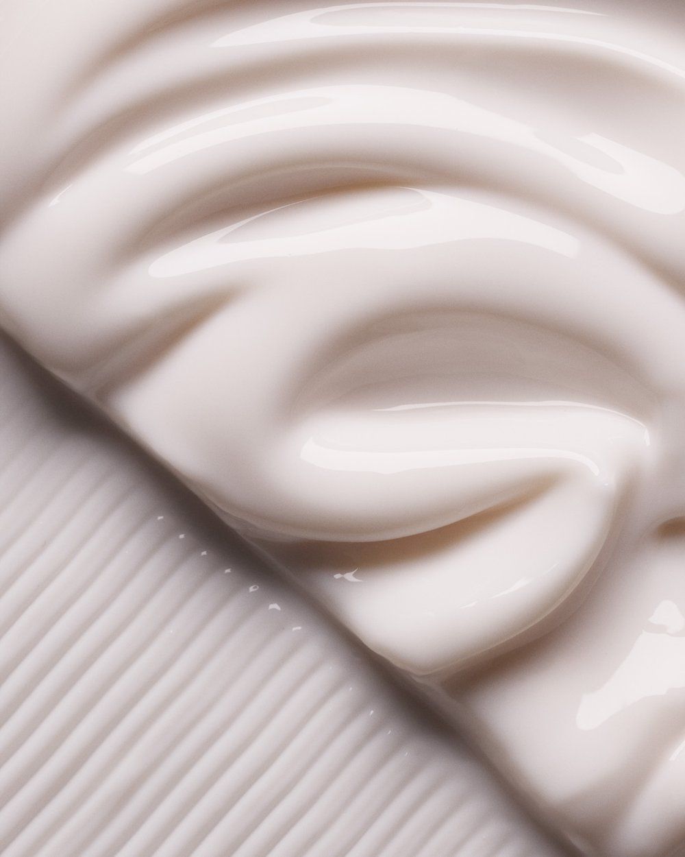 Close-up of creamy white fabric with soft folds and diagonal ribbed texture.