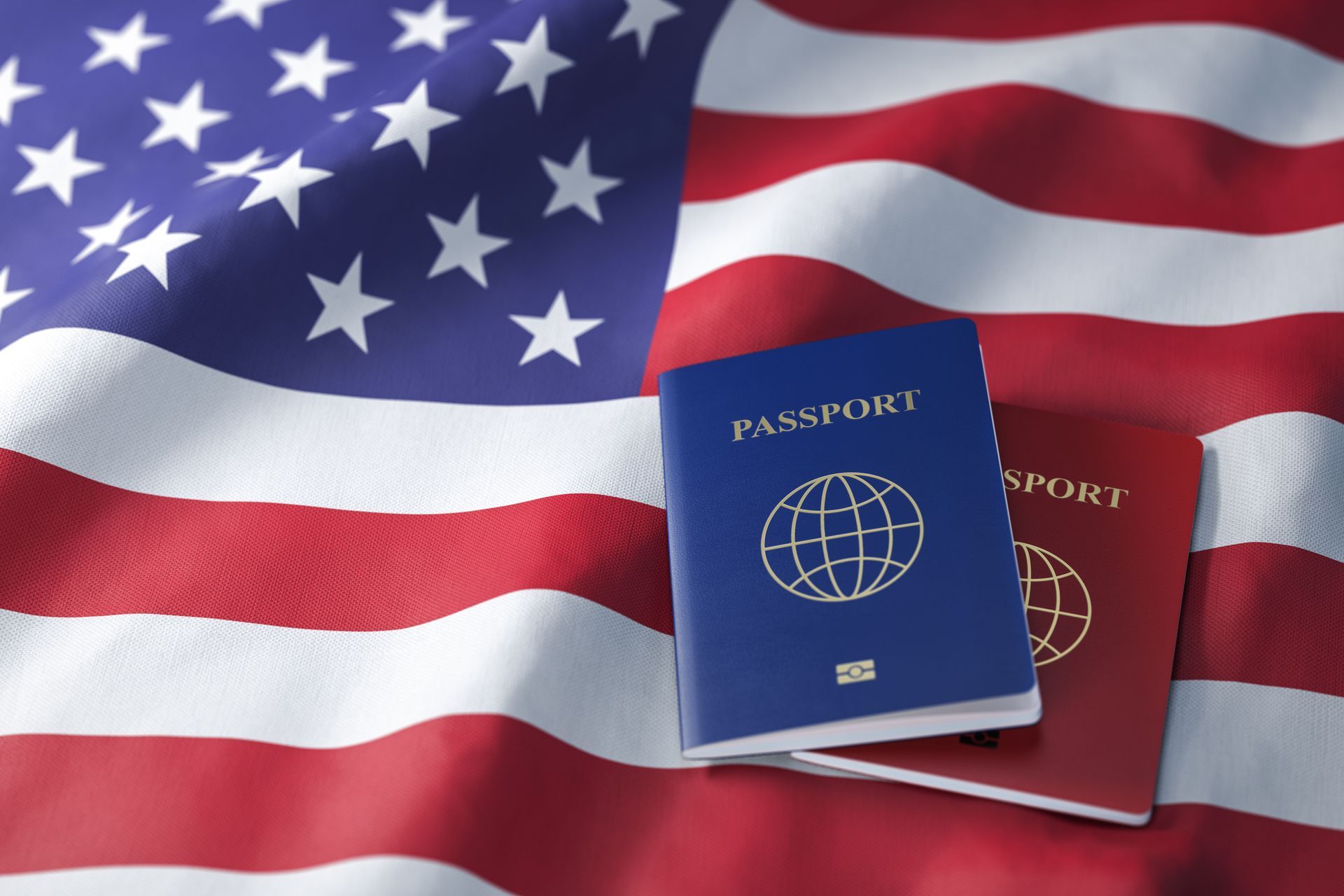 Two passports, blue and red, on an American flag.