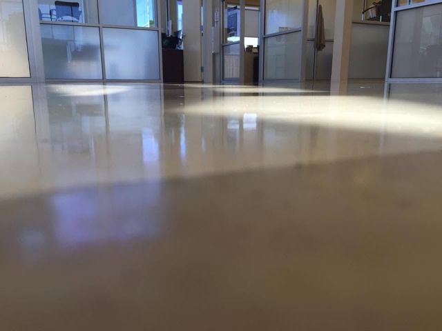 Low-angle view of a bright hallway with polished floor and doors in the background