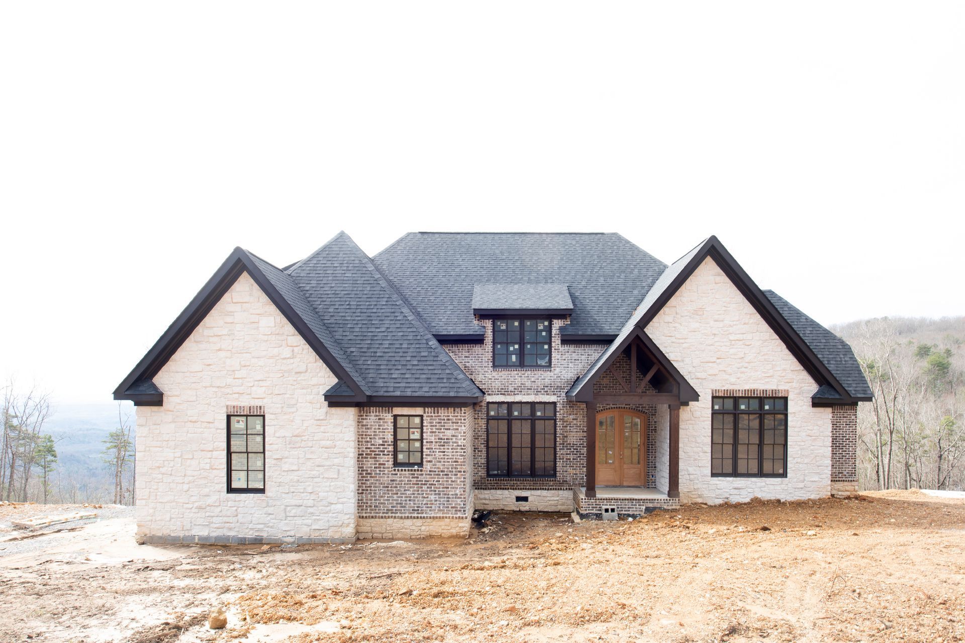 A house that is being built with a lot of windows and a garage.