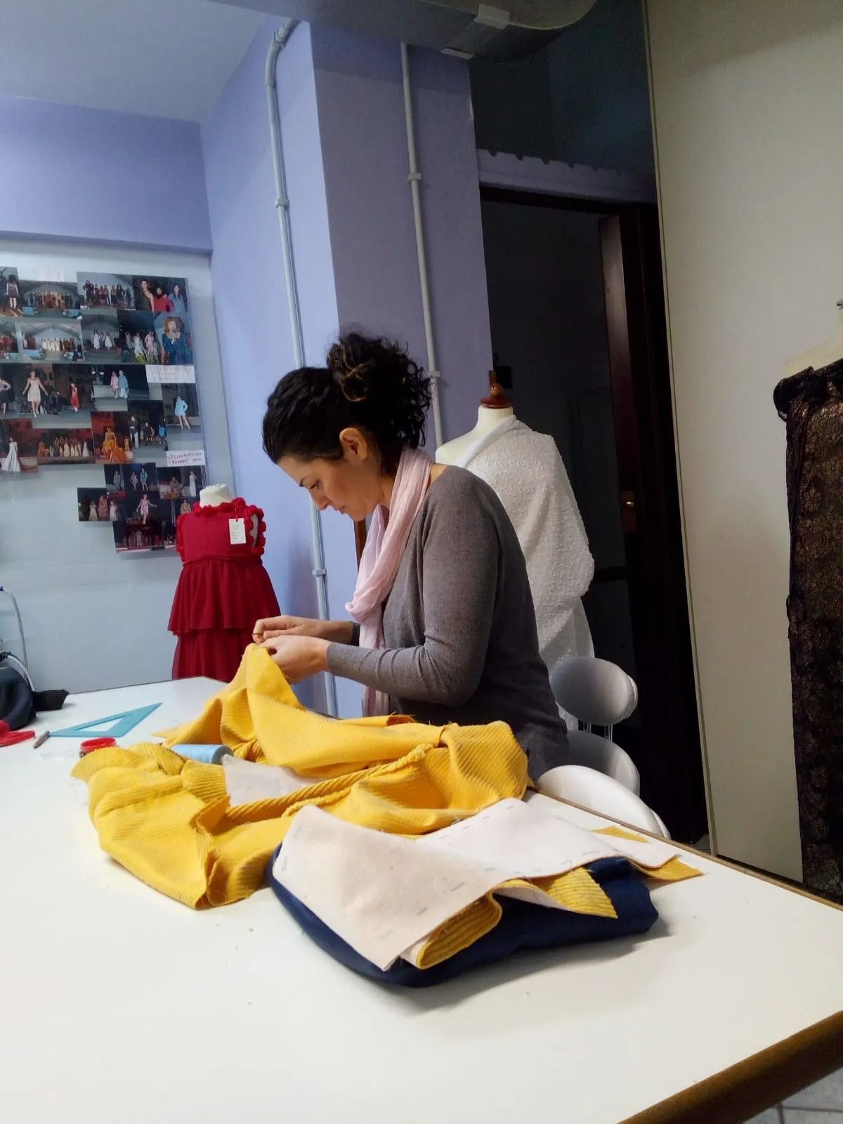 Una donna è seduta a un tavolo e lavora su un pezzo di tessuto
