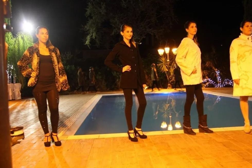 Un gruppo di donne è in piedi davanti a una piscina indossando pellicce