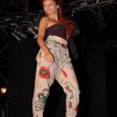 Una donna è in piedi su un palco e indossa una tuta floreale.