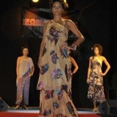 Una donna cammina su una passerella indossando un abito floreale.