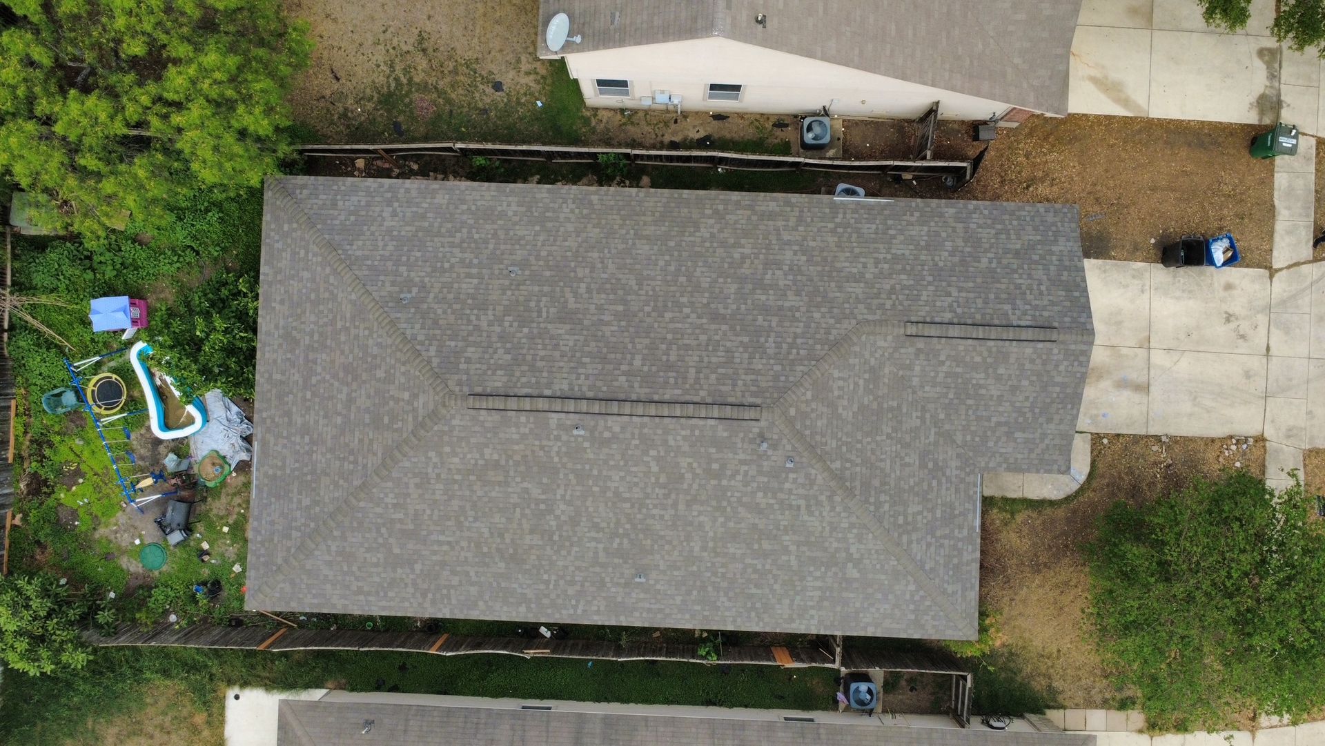 A brick house with a white gutter and a black roof.