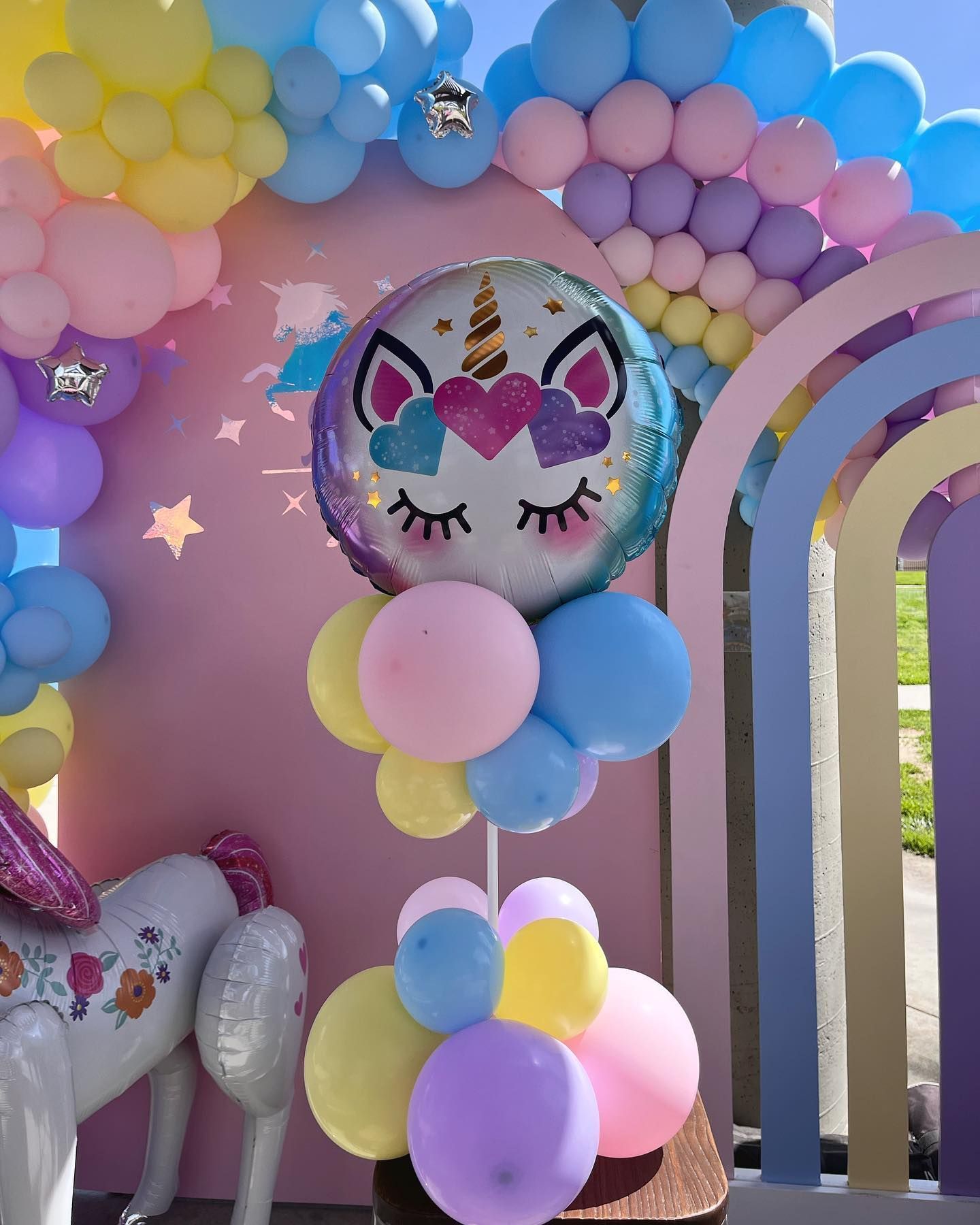 a unicorn balloon is surrounded by colorful balloons