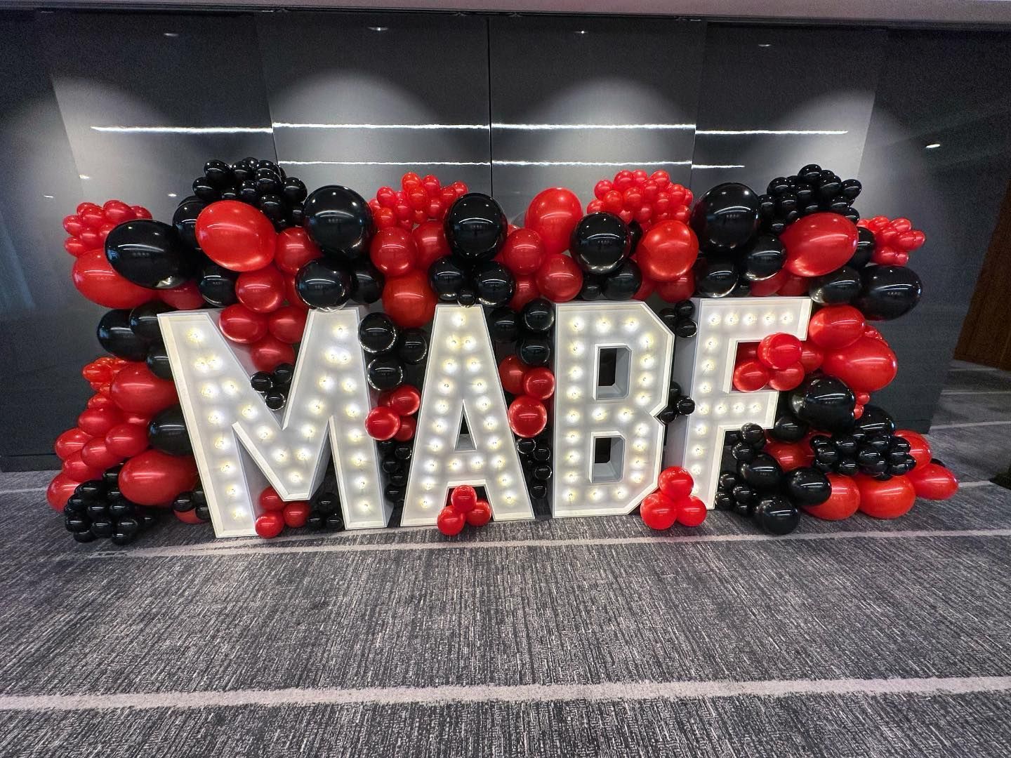 the word mabf is surrounded by red and black balloons