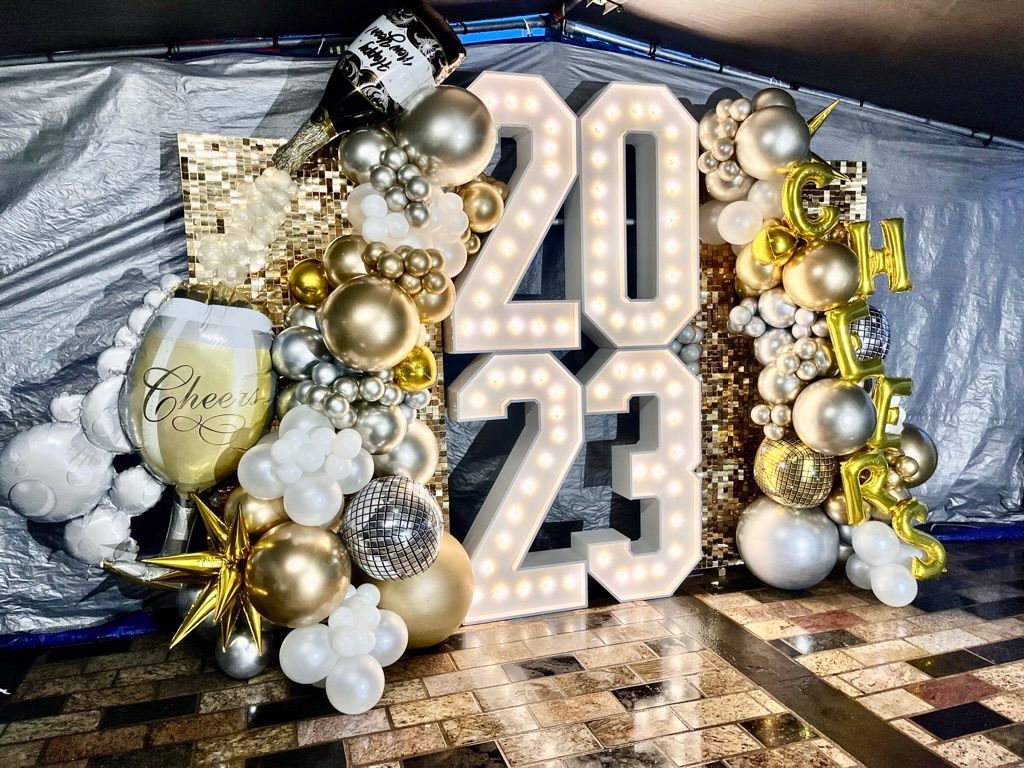 a large sign with the number 20 and 23 surrounded by balloons and lights
