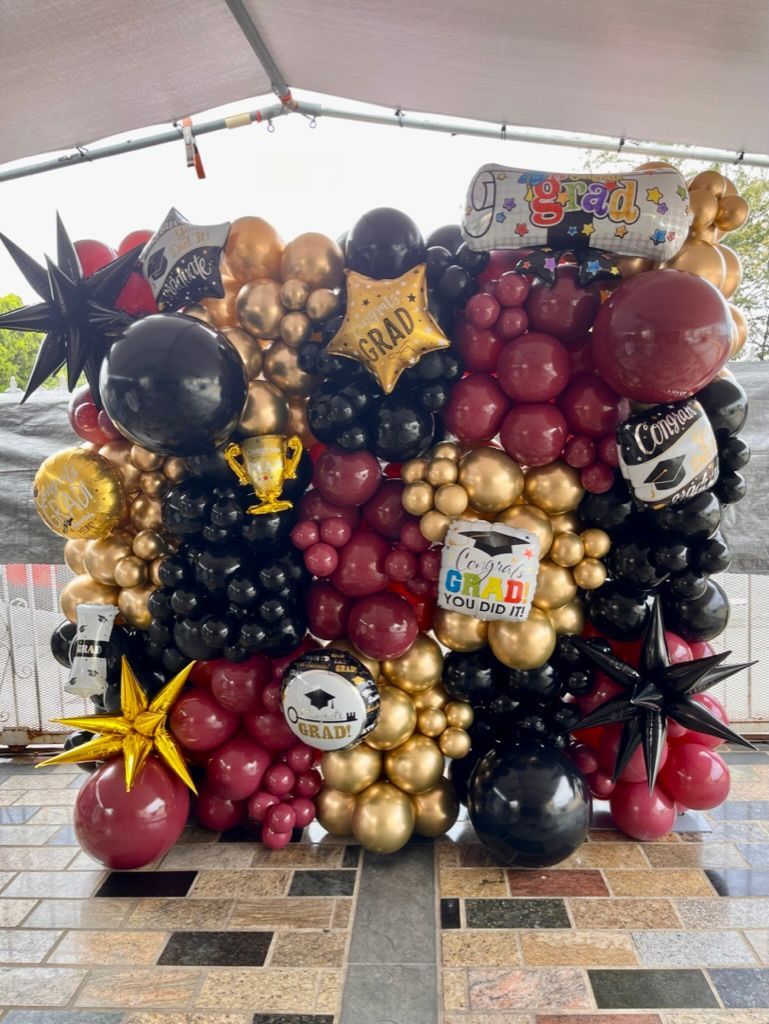 a wall of balloons sitting on top of a tiled floor