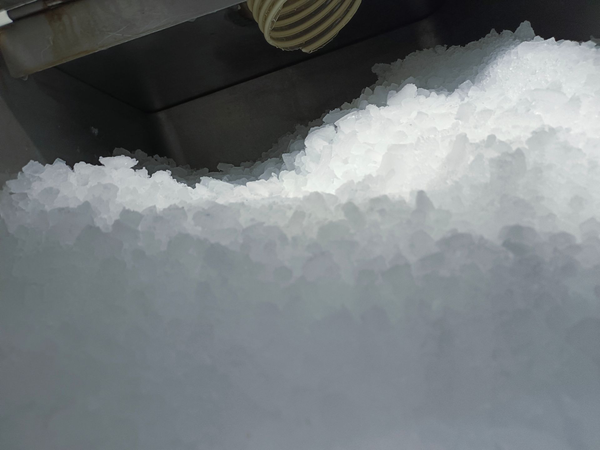 Snow piled against a vehicle tire in a close-up winter scene