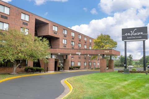 Brick apartment building with covered entrance and green lawn, sign reading “Lindbergh” at the roadside.