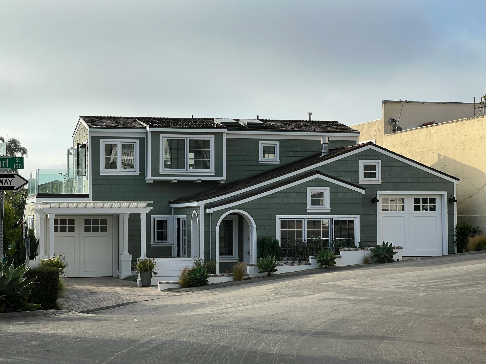 A large green house with a white garage door