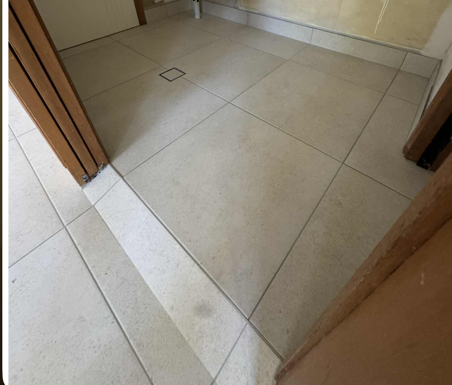 Empty Tiled Hallway with A Small Floor Hatch Near a Doorway — Midcoast Wall & Floor Tiling in Sapphire Beach, NSW